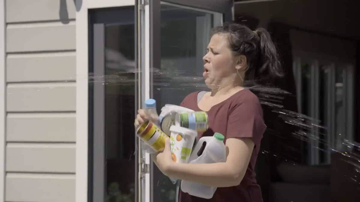 Video still of a girl taking out recycling, part of a environmental campaign produced by Wonderlab