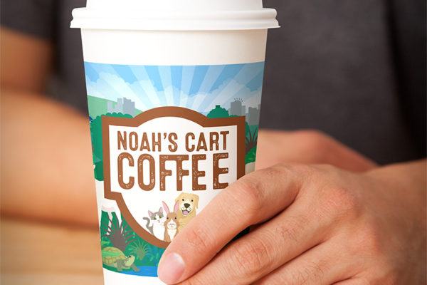 Person holding a branded coffee cup designed by ad agency Wonderlab