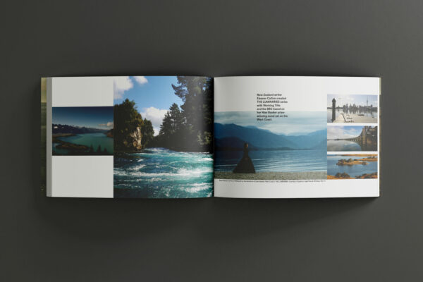 An open book with pictures of a lake and mountains.