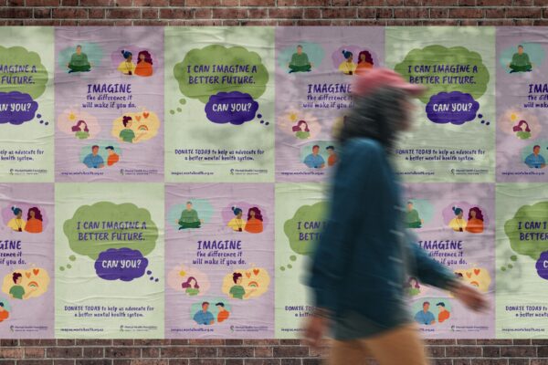 A woman is walking past a group of posters on a wall.