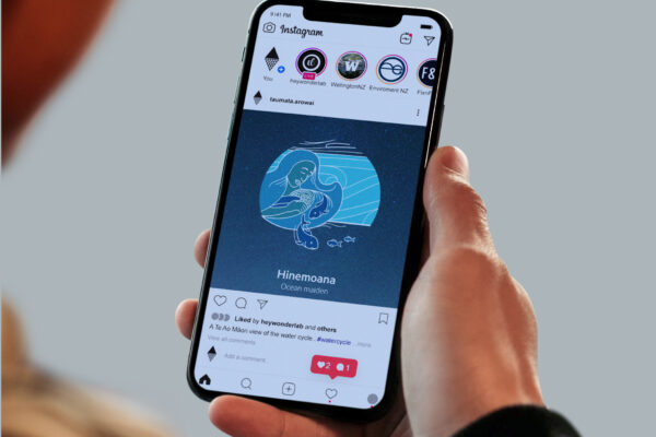 A person holding an iphone with an image of a whale on it.