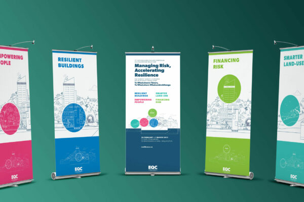 Four roll up banners on a green background.