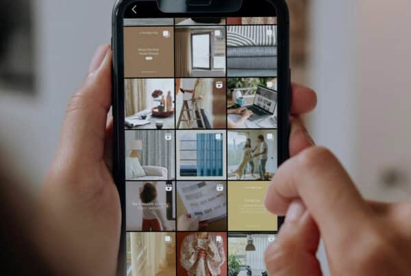 A person is holding a smartphone displaying an Instagram profile with a grid of various home decor-related posts.